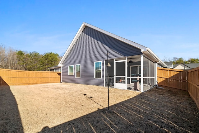 back of property featuring a fenced backyard and a sunroom