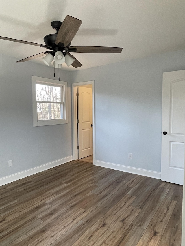 unfurnished room featuring a ceiling fan, dark wood-style floors, and baseboards