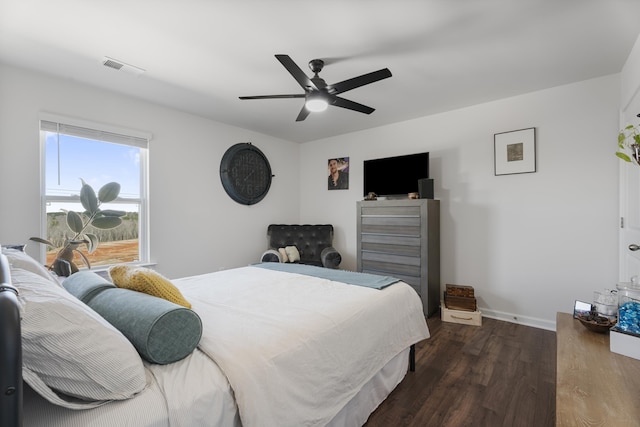 bedroom with ceiling fan, visible vents, baseboards, and wood finished floors