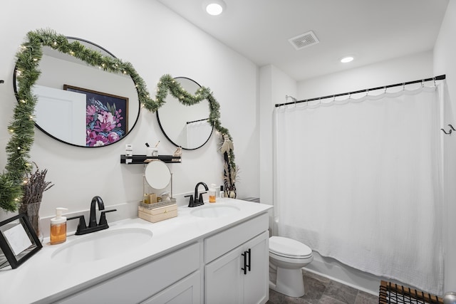 full bath featuring a sink, visible vents, toilet, and double vanity