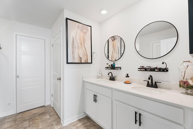 full bath with double vanity, recessed lighting, baseboards, and a sink