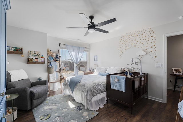 bedroom with a ceiling fan, wood finished floors, and baseboards