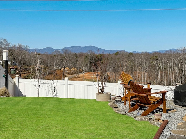 view of yard with a mountain view, a forest view, and fence