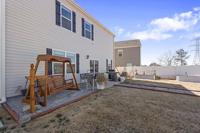 rear view of house featuring a patio, a vegetable garden, and fence