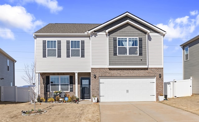 view of front facade with brick siding, an attached garage, driveway, and fence