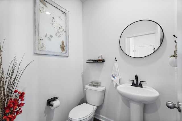 half bath with toilet and baseboards