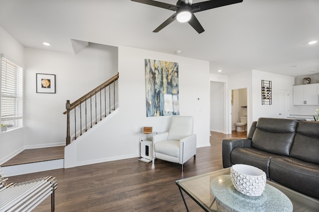 living area with stairway, baseboards, ceiling fan, and wood finished floors