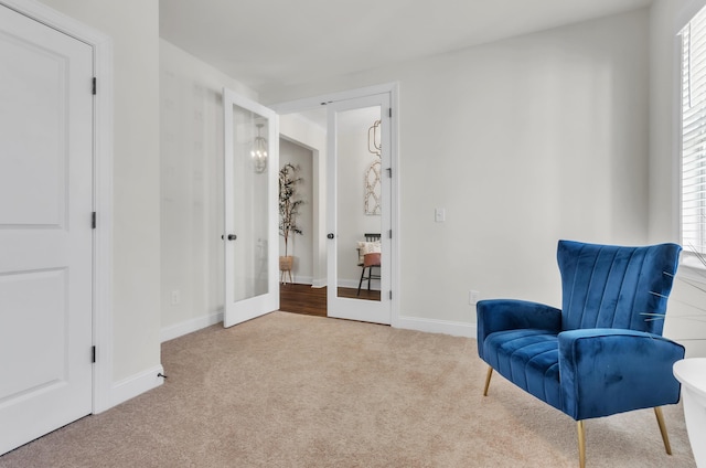 sitting room with french doors, baseboards, carpet, and a healthy amount of sunlight