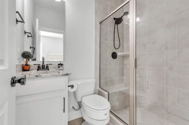 full bathroom featuring vanity, a shower stall, and toilet