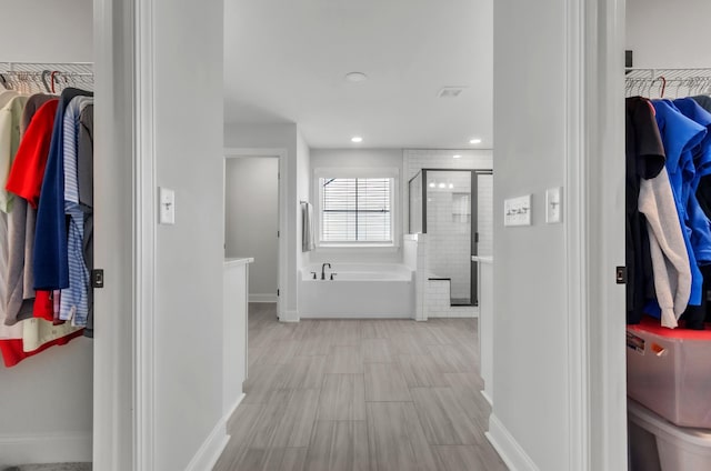 hall with recessed lighting and baseboards