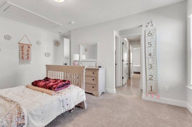 bedroom featuring attic access, baseboards, and light carpet