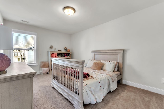 bedroom with visible vents, light carpet, and baseboards