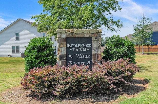 community sign featuring a lawn and fence