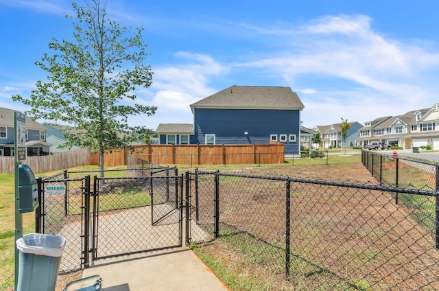 view of yard with a gate, fence, and a residential view