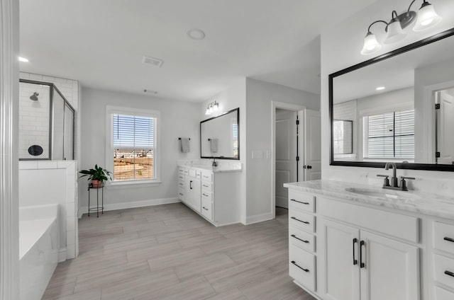 full bathroom featuring visible vents, a stall shower, baseboards, and a sink