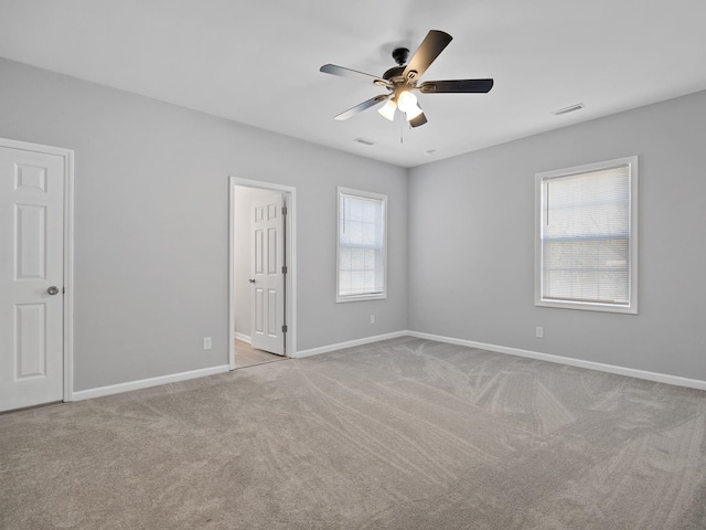 unfurnished room with baseboards, carpet, visible vents, and ceiling fan