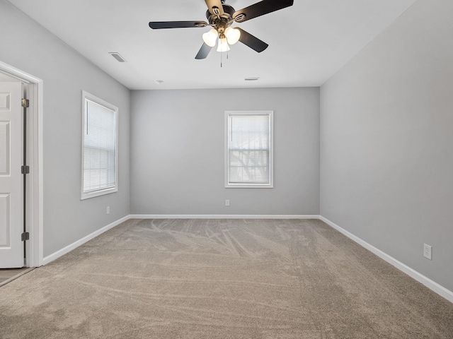 empty room featuring visible vents, baseboards, ceiling fan, and carpet flooring