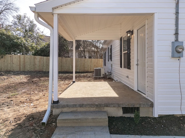 view of patio with central air condition unit and fence