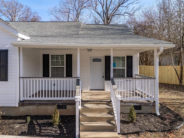 view of front of property with crawl space, fence, a porch, and a shingled roof