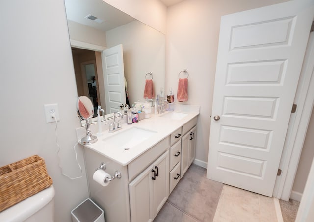 full bath featuring a sink, visible vents, toilet, and double vanity