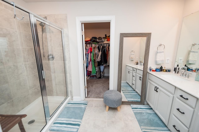 full bathroom featuring tile patterned floors, vanity, a spacious closet, and a shower stall