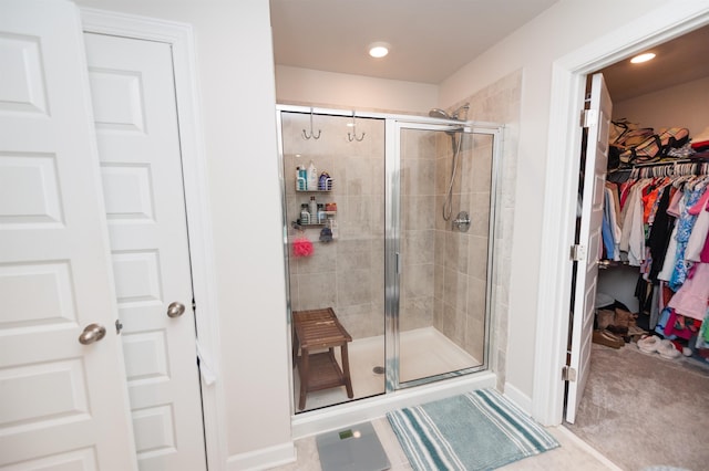 bathroom with a stall shower and a spacious closet