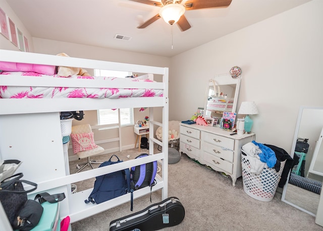 bedroom with visible vents, light colored carpet, and a ceiling fan