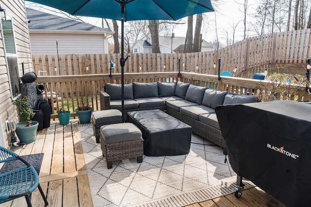 wooden terrace featuring an outdoor hangout area and a fenced backyard