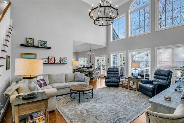 living room with an inviting chandelier, wood finished floors, and ornamental molding