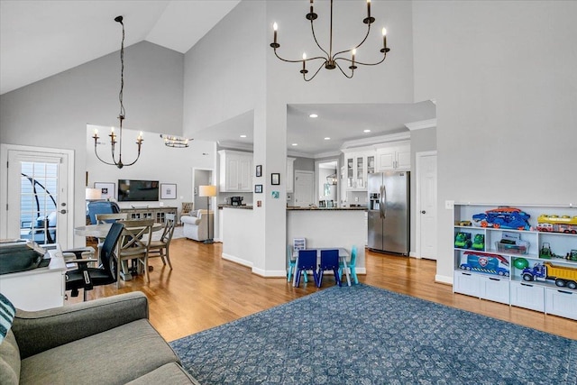 living room featuring an inviting chandelier, wood finished floors, and high vaulted ceiling