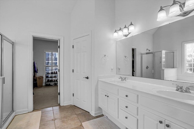 full bath with tile patterned flooring, a stall shower, double vanity, and a sink