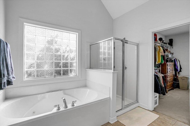 bathroom featuring a whirlpool tub, a spacious closet, a shower stall, and vaulted ceiling