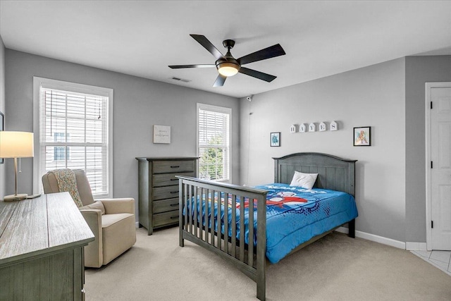 bedroom featuring visible vents, light colored carpet, baseboards, and ceiling fan