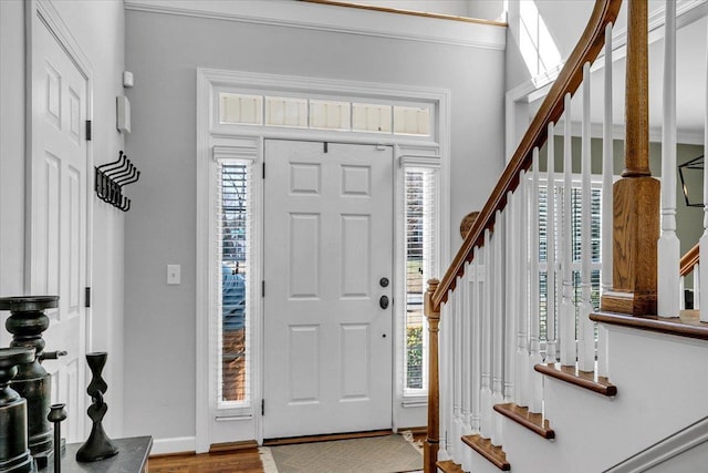 foyer entrance featuring stairway, baseboards, and wood finished floors