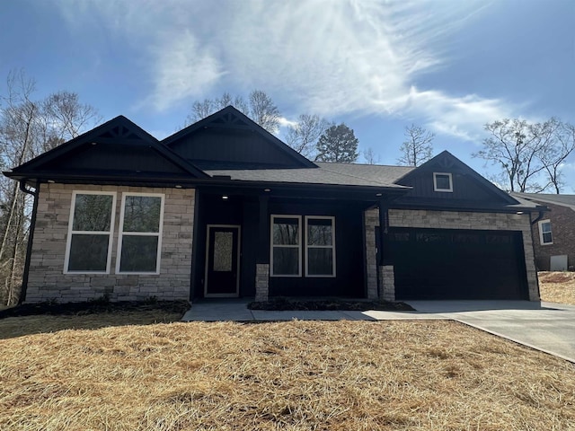 view of front of home with a garage, stone siding, and driveway