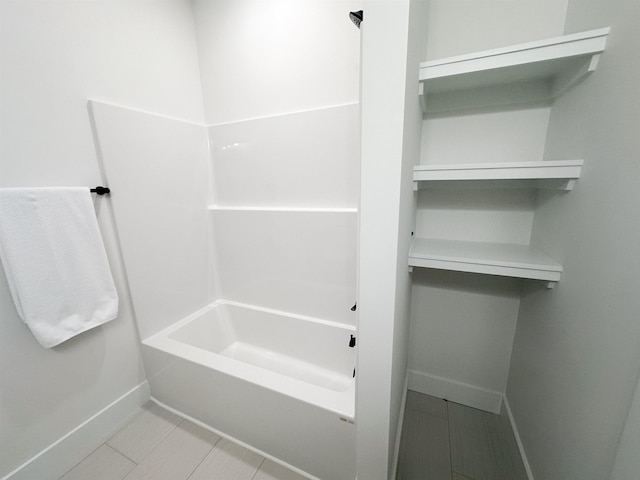 bathroom with baseboards and shower / washtub combination