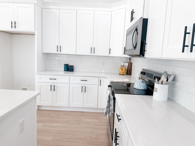 kitchen featuring tasteful backsplash, stainless steel electric range, white cabinets, and light wood finished floors