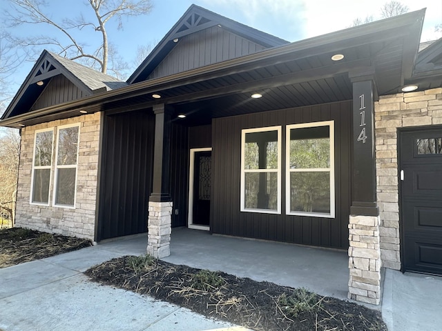 entrance to property featuring stone siding and board and batten siding