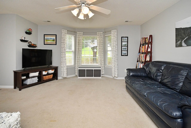 living room with baseboards, a ceiling fan, visible vents, and light carpet