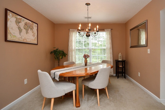 dining room with a notable chandelier, visible vents, baseboards, and light carpet