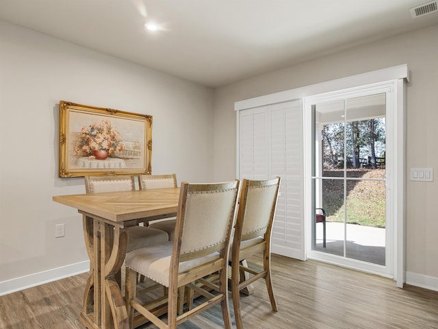 dining space featuring visible vents, baseboards, and wood finished floors