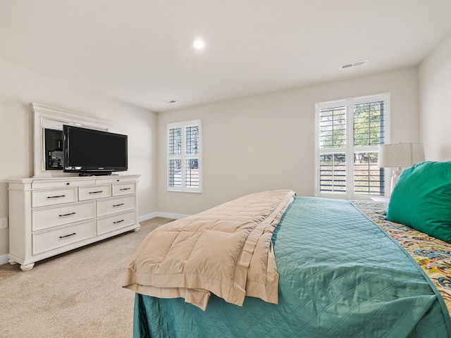 bedroom with light colored carpet, visible vents, and baseboards