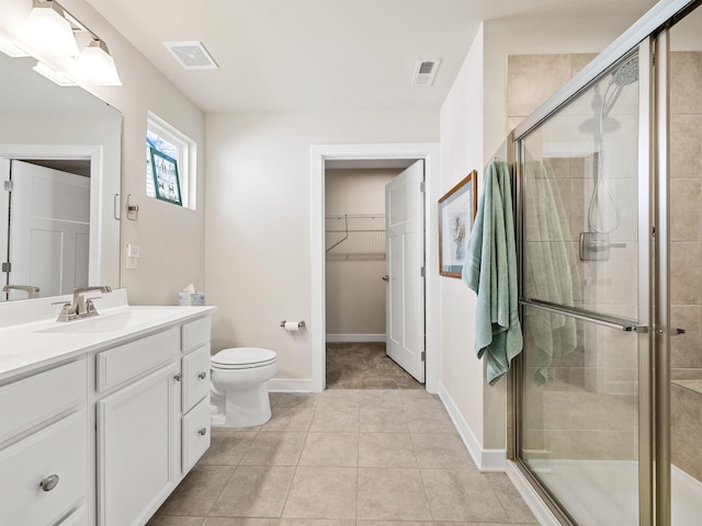 bathroom featuring visible vents, a spacious closet, a stall shower, and vanity