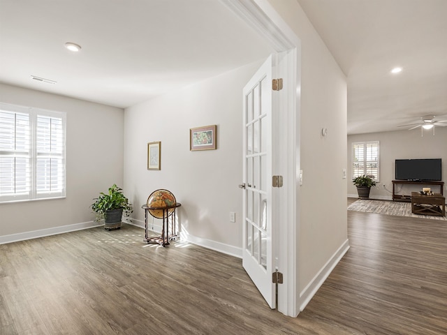 hallway featuring visible vents, recessed lighting, baseboards, and wood finished floors