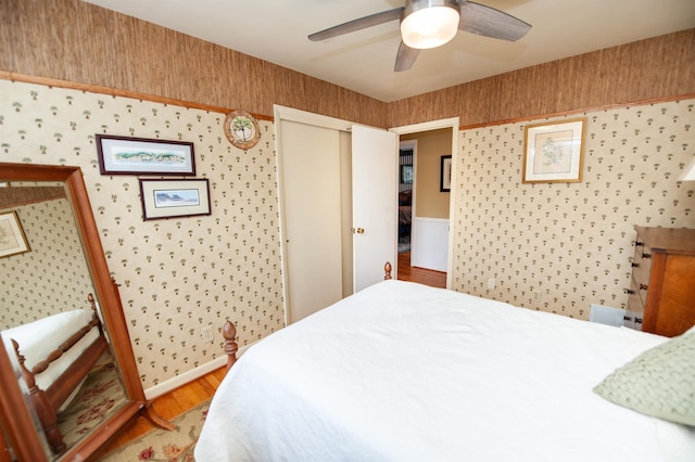 bedroom with a closet, light wood-style floors, and wallpapered walls