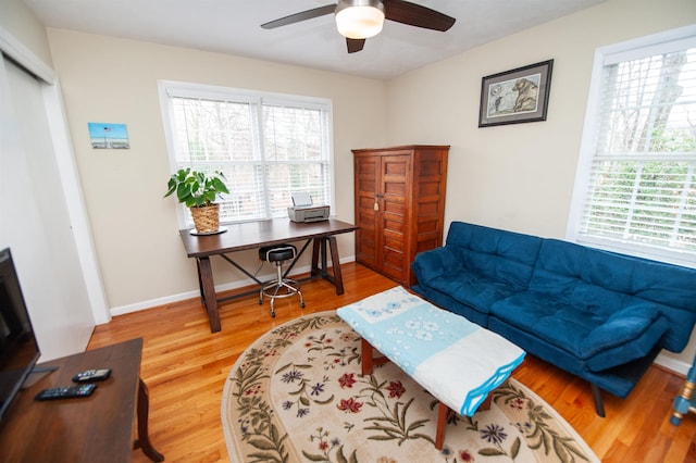 office area with baseboards, a ceiling fan, and wood finished floors