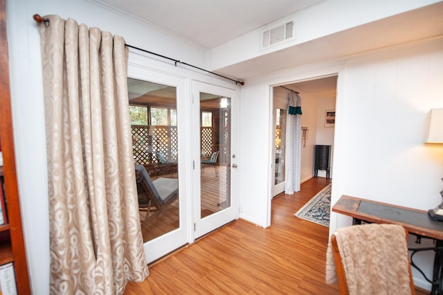 home office with visible vents, crown molding, and wood finished floors