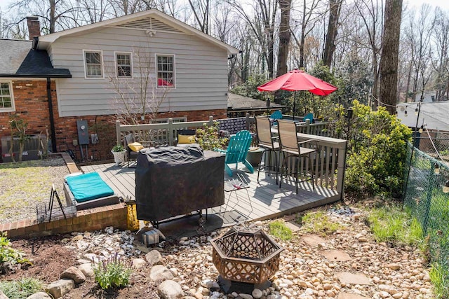 view of patio / terrace with a fire pit, a deck, and fence