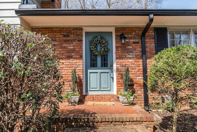 view of exterior entry with brick siding