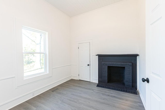 unfurnished living room with visible vents, wood finished floors, and a fireplace